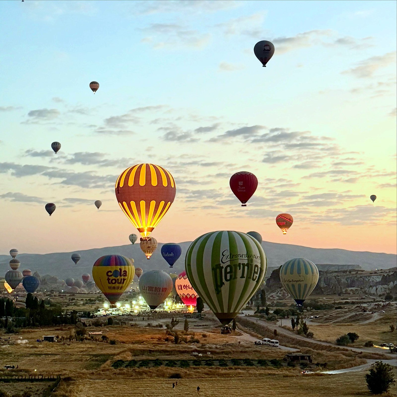 Dezenas de balões coloridos decolando ao amanhecer na Capadócia