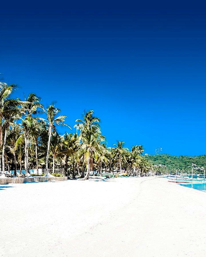 Areia branca, coqueiros e mar azul-turquesa da White Beach em Boracay, Filipinas